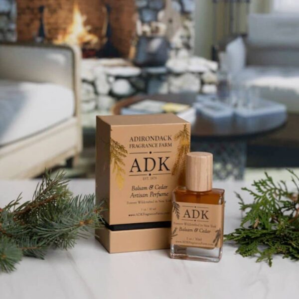 Gold ADK designed Balsam Cedar Perfume Spray Bottle with box on a winter home background