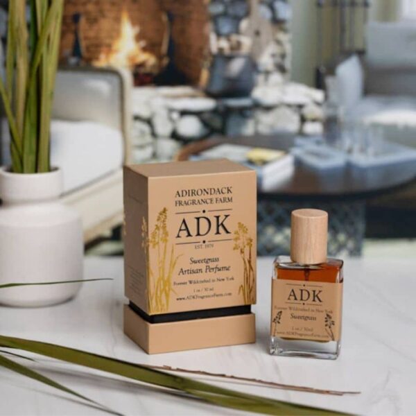 Gold ADK designed Sweetgrass Perfume Spray Bottle with Box on a winter home background