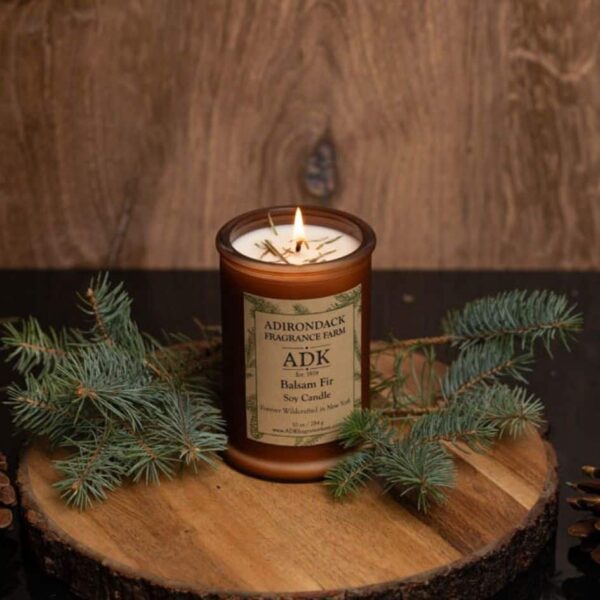 Balsam Fir Candle with an ADK Label on a wooden plate. 10oz