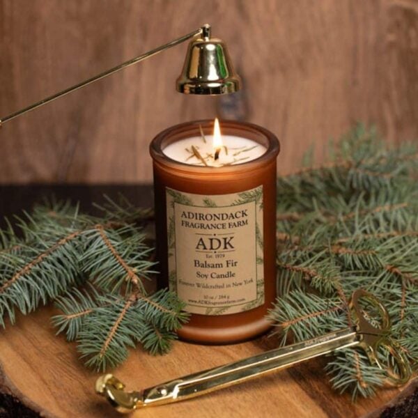 Balsam Fir Candle with an ADK Label on a wooden plate. 10oz with trimmer and snuffer