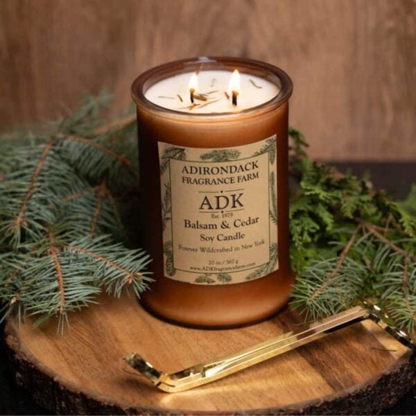 Balsam Cedar Candle with ADK label 20oz on a wooden plate with trimmer