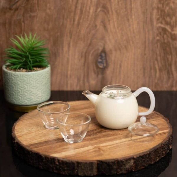Balsam Green Tea Teapot Candle with glass cups on a wooden plate