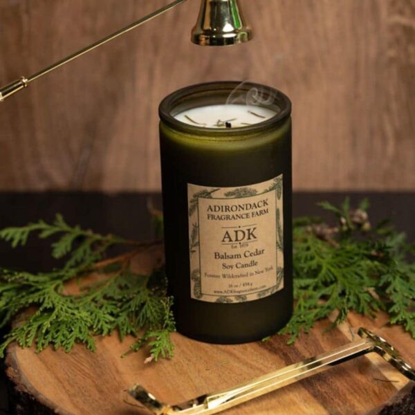 Balsam Cedar Candle 16oz with ADK Label on a wooden plate with wick snuffer and wick trimmer