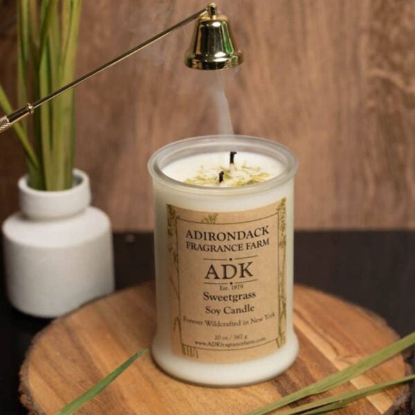 Sweetgrass Candle 20oz with ADK label on a wooden plate with wick snuffer