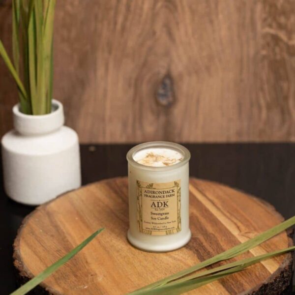 Sweetgrass Candle 4.5oz with ADK label on a wooden plate